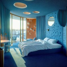 a bedroom with blue walls and round windows