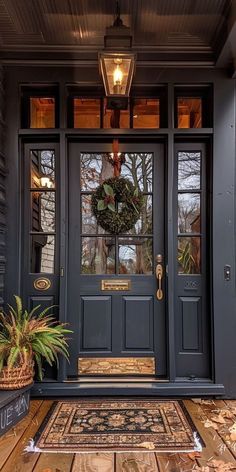 a front door with a wreath and potted plants