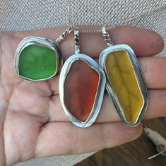 These autumn leaf pendant necklaces are handcrafted using genuine, authentic, natural sea glass in red, yellow and green.  The backplate of each pendant is cut out to look like the veining in leaves. Each piece of sea glass is bezel set in .999 fine silver, antique inspired gallery wire and is on a sterling silver chain. Each backplate has a cut out that allows the light to shine through the glass. The sea glass we use is 100% authentic, created naturally by the waves and the sand.  We do not alter our sea glass.  The way you see it is the way it looked on the beach, except for a good washing with dish soap 😊 Since sea glass is created by nature, no two pieces of sea glass are identical, making every piece of sea glass jewelry truly unique . Sea glass starts off as someone's trash that ha Lucky Jewelry, Autumn Leaf, Sea Glass Necklace, Green Sea, Antique Inspiration, Leaf Pendant, Sea Glass Jewelry, Handmade Necklace, Glass Necklace