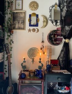 a living room filled with furniture and pictures on the wall next to a table topped with candles