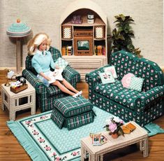 a doll sitting in a chair next to a blue couch and table with a white cat on it