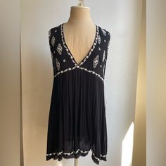 -Free People Embroidered Swing Top -Deep V-Neck, Split Back Detail, Swing Style Fit -White Embroidery -Never Worn -Rayon And Polyester Blend V-neck Tops With Embroidered Hem, Casual Black Embroidered V-neck Top, Casual V-neck Embroidered Top, Black Embroidered V-neck Top For Summer, Black V-neck Embroidered Top For Summer, Black Embroidered V-neck Top, V-neck Embroidered Top For Beach, White Embroidery, Free People Black