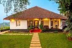 a small white house sitting on top of a lush green field