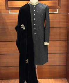 With our stunning Black Embroidered Sherwani for men, you can exude sophistication while combining classic style and contemporary appeal. The entire sherwani is covered in an exquisite floral design that is painstakingly embroidered onto the opulent silk fabric. Finished with zardozi embroidery by hand on the collar and cuffs, this piece exudes subtle elegance. The dispersed flower embroidery adds a classic and elegant appearance, resulting in a tasteful blend of traditional and modern design el Ceremonial Winter Sherwani With Dabka Embroidery, Ceremonial Winter Sherwani With Dabka, Ceremonial Winter Sets With Traditional Drape, Traditional Ceremonial Sherwani For Winter, Winter Ceremonial Sherwani With Zari Work, Fitted Wedding Kurta For Winter, Traditional Winter Ceremonial Sherwani, Fitted Winter Wedding Kurta, Semi-stitched Traditional Wear For Winter Wedding