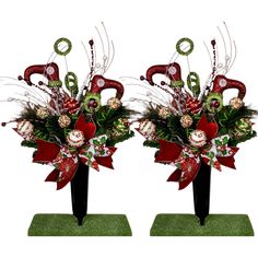 two black vases with red and green flowers in them on top of each other