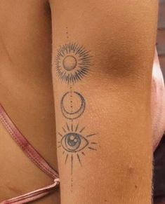 a woman's arm with an eye and sun tattoo on her left side,