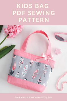 a pink and gray bag sitting on top of a white table next to some flowers