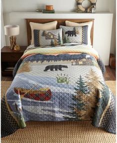 a bed with a bear quilt and pillows on it