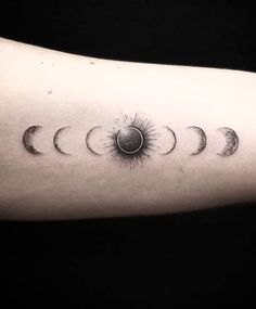 the phases of the sun and moon tattoo on the left arm, which is black and white