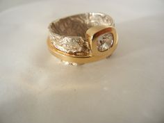 a gold and silver ring sitting on top of a white table