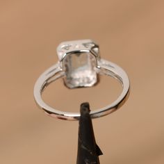 It is real natural aquamarine ring, the emerald cut aquamarine is about 5mm*7mm, weight about 0.86 carats. The basic metal is sterling silver and plated with rhodium. To change the metal to a solid gold (white/rose) or platinum is also available, please ask for a quotation if you want. You can also go to my shop Home for more elegant rings: https://www.etsy.com/shop/godjewelry?ref=hdr_shop_menu Aquamarine is the birthstone of January. More aquamarine rings: https://www.etsy.com/shop/godjewelry?r Diamond White Emerald Cut Halo Jewelry, Silver Ring With Rectangular Blue Topaz, Silver Rings With Rectangular Blue Topaz, Silver Topaz Ring With Rectangular Blue Stone, Silver Blue Topaz Ring With Rectangular Stone, Silver Emerald Ring With Asscher Cut Cubic Zirconia, White Gold Aquamarine Jewelry With Halo Setting, Emerald Cut Cubic Zirconia Topaz Ring With Halo Setting, Silver Radiant Cut Emerald Ring With Halo Setting