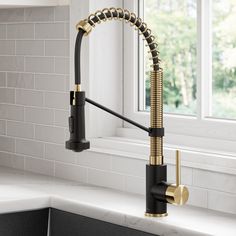 a kitchen faucet with a black and gold pull - down spout is shown in front of a window