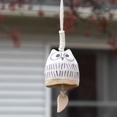 an owl shaped bird feeder hanging from a tree