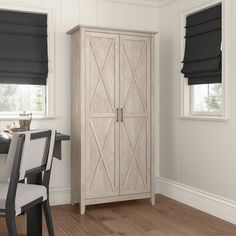 a white armoire sitting next to a window with blue blinds on the windowsill