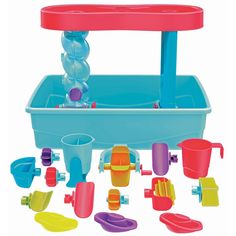 an assortment of plastic toys including a water fountain and sand buckets, on a white background