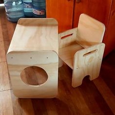 two wooden toys sitting on top of a hard wood floor next to bottles of water