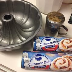 two cinnamon rolls sitting on top of a counter next to a bundt cake pan