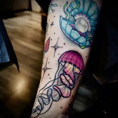 a person with a tattoo on their arm has a jellyfish and an octopus in space