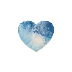 a blue heart shaped paper cutout with watercolors on it and the sky in the background