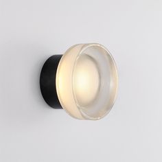 a light that is on the side of a wall with a black and white base