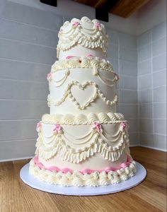 a three tiered wedding cake sitting on top of a wooden table