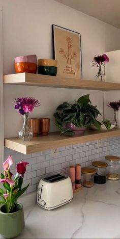 the kitchen counter is covered with flowers and other things on it's shelving