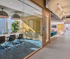 an empty conference room with glass walls and chairs