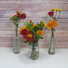 three vases filled with different types of flowers