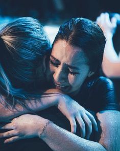 two women embracing each other in the dark