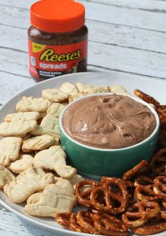 a plate with pretzels, dip and peanut butter on it