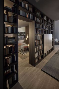 an open bookcase with many books on it in a living room next to a couch