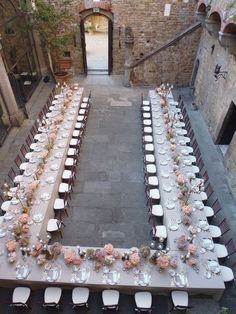 an aerial view of a long table set up for a formal function in the courtyard