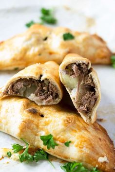 two pastries with meat, cheese and parsley