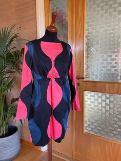 This is a cute dress from Finnish company Marimekko.   Satin cotton. Size 40, fits a today's size Medium.    Good condition. The shape is inspired with the 1950's  with marked waist and wide skirt. Pockets in sides. A bit longer in the back. Inner lining. Zipper in the back. Warm Pink and Blue on Black. big Graphics, classic pattern. Retro. Don't hesitate to ask for measurements in cm or inches. Pit-pit 51,5cm (103cm around) Waist 86cm ♪♫♬ Vintage Blue Cotton Mini Dress, Knee-length Retro Cotton Mini Dress, Retro Knee-length Cotton Mini Dress, Fitted Retro Cotton Mini Dress, Retro Fitted Cotton Mini Dress, Retro Cotton Dresses For Work, Retro Cotton Workwear Dress, Marimekko Dress, Wide Skirt