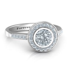 a white gold engagement ring with diamonds on the band and an halo setting in the center