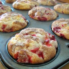 freshly baked strawberry muffins sitting on top of a baking pan