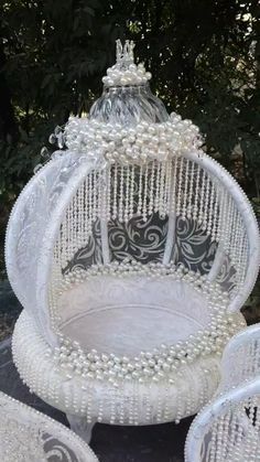 a white birdcage with pearls on it