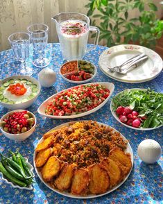 a table topped with plates and bowls filled with food