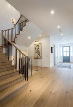 a staircase leading up to the second floor in a house with white walls and wood floors