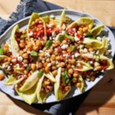 a white plate topped with lettuce and chickpeas