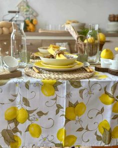 the table is set with lemons and plates