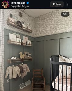 a baby's room with green walls and wooden shelves on either side of the crib