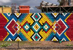 a colorfully painted fence in front of a construction site with scaffolding on it