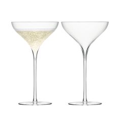 two wine glasses filled with champagne on a white background