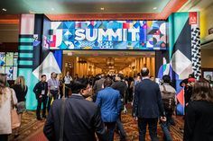 a group of people standing in front of a large sign that says summit on it