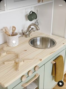 a kitchen counter with a sink and wooden utensils