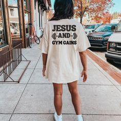 "Introducing our \"Jesus and Gym Gains\" Shirt - a harmonious blend of faith and fitness for those who find strength in both the divine and the gym. This shirt celebrates the holistic approach to strength - both spiritual and physical. HOW TO ORDER: 1. Choose size/color options 2. Select the quantity 3. Click \"Add to Cart\" 4. Proceed to payment SHIRT MATERIAL: - 100% cotton (fiber content may vary for different colors) - Medium fabric  - Classic fit - Tear-away label - Runs true to size SIZING: While these T shirts are unisex and run true to size, we would recommend sizing up 1-2 sizes for an oversized look! CARE INSTRUCTIONS: - Machine wash cold, inside out - Hang dry or tumble dry low - Do not bleach or iron directly on design PROCESSING AND SHIPPING: 3-5 business days for processing A Christian Workout Shirts, Gym Merchandise, Jesus Merch, Workout T Shirts, Faith And Fitness, Pump Covers, Powerlifting Gym, Gym Tshirt, Gym Gains