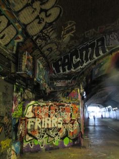 a man riding a skateboard down a graffiti covered wall