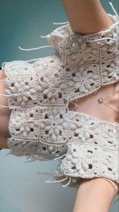 a crocheted piece of clothing with holes in the middle and buttons at the bottom