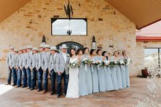 a large group of people standing next to each other in front of a stone building